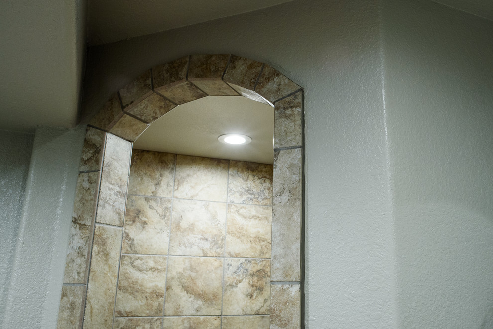 Cette photo montre une grande salle de bain principale sud-ouest américain en bois brun avec un placard en trompe-l'oeil, une douche ouverte, WC à poser, un carrelage multicolore, des plaques de verre, un mur beige, un sol en carrelage de porcelaine, un lavabo encastré et un plan de toilette en granite.