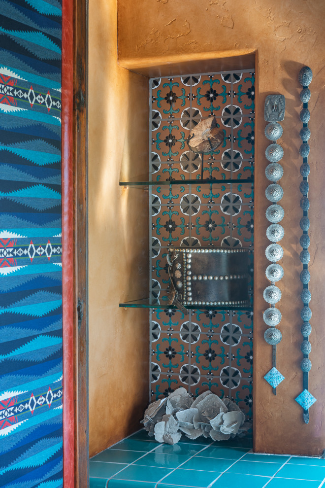 Mediterranes Badezimmer mit hellen Holzschränken, blauen Fliesen, Einbauwaschbecken, Waschtisch aus Holz, Falttür-Duschabtrennung und brauner Waschtischplatte in Sonstige