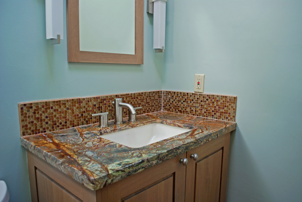 Inspiration for a small southwestern 3/4 multicolored tile and glass sheet bathroom remodel in Albuquerque with raised-panel cabinets, light wood cabinets, blue walls, an undermount sink and marble countertops