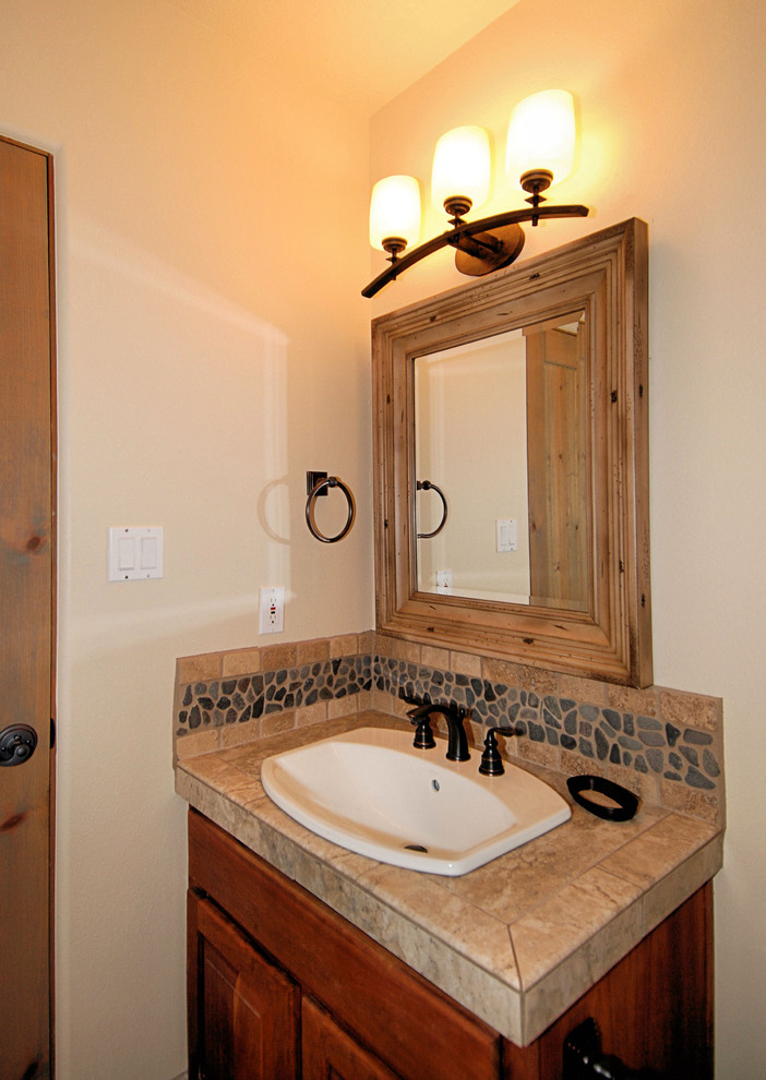 Foto di una stanza da bagno con doccia stile americano di medie dimensioni con ante con riquadro incassato, ante marroni, WC monopezzo, piastrelle blu, piastrelle in ceramica, pareti bianche e lavabo da incasso