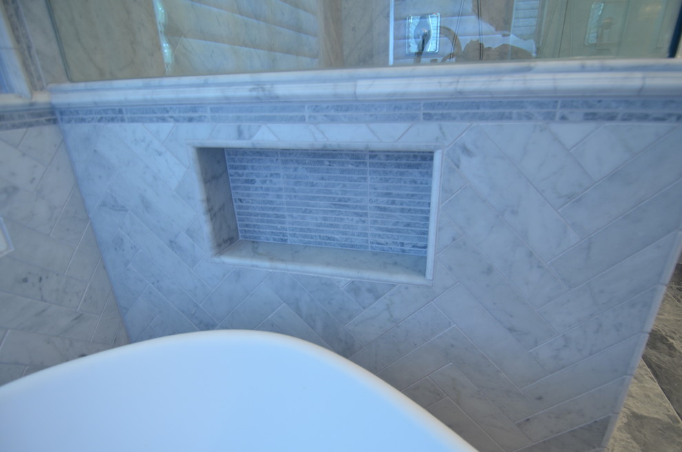 Пример оригинального дизайна: большая главная ванная комната в стиле неоклассика (современная классика) с фасадами островного типа, темными деревянными фасадами, отдельно стоящей ванной, душем без бортиков, раздельным унитазом, серой плиткой, каменной плиткой, синими стенами, мраморным полом, врезной раковиной и мраморной столешницей