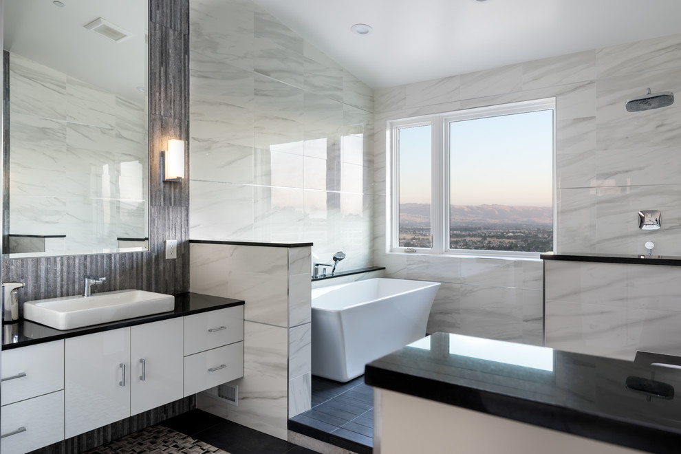 Inspiration för stora moderna svart en-suite badrum, med släta luckor, vita skåp, ett fristående badkar, en öppen dusch, grå kakel, marmorkakel, ett fristående handfat, bänkskiva i kvarts och med dusch som är öppen