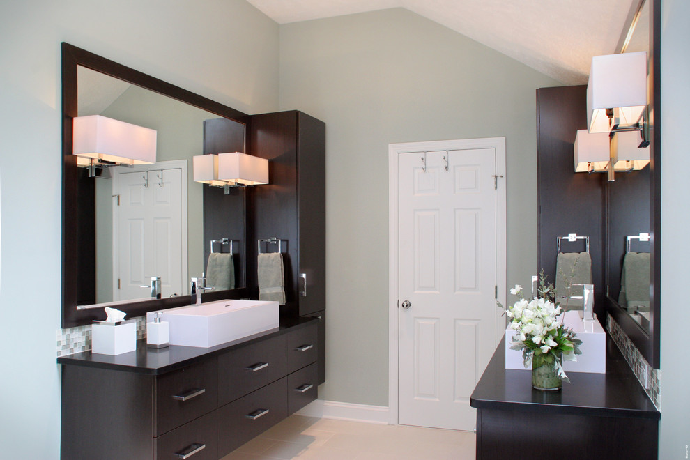 Medium sized modern ensuite bathroom in Cleveland with flat-panel cabinets, brown cabinets, a freestanding bath, a walk-in shower, a one-piece toilet, green tiles, glass sheet walls, green walls, porcelain flooring, a vessel sink, soapstone worktops, grey floors and a hinged door.