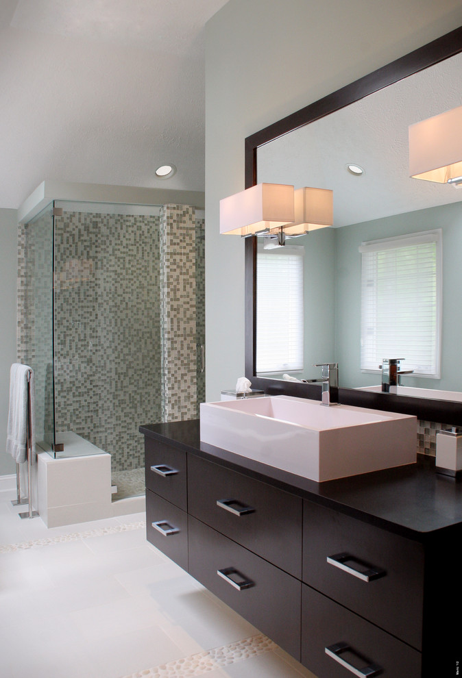 Medium sized modern ensuite bathroom in Cleveland with flat-panel cabinets, brown cabinets, a freestanding bath, a walk-in shower, a one-piece toilet, green tiles, glass sheet walls, green walls, porcelain flooring, a vessel sink, soapstone worktops, grey floors and a hinged door.