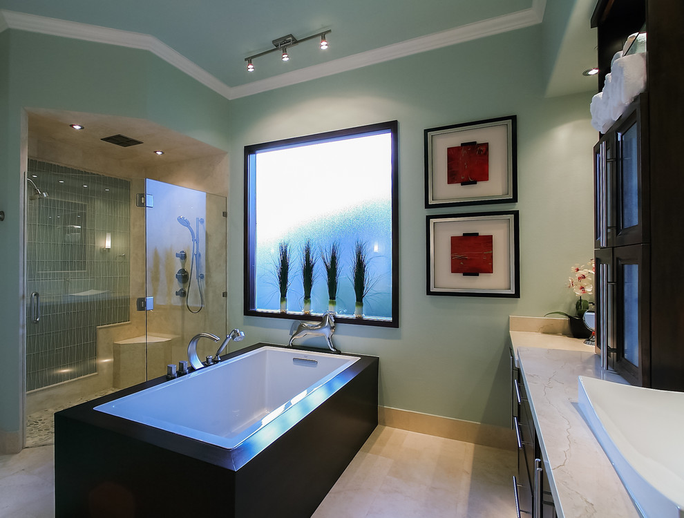 Idéer för att renovera ett mellanstort funkis en-suite badrum, med ett fristående handfat, luckor med glaspanel, skåp i mörkt trä, marmorbänkskiva, ett fristående badkar, en kantlös dusch, en toalettstol med separat cisternkåpa, beige kakel, gröna väggar och travertin golv