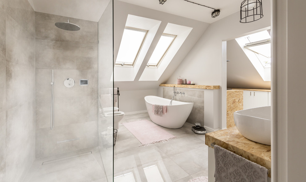 На фото: главная ванная комната в современном стиле с отдельно стоящей ванной, угловым душем, белыми стенами, настольной раковиной, серым полом, бежевой столешницей, биде и открытым душем