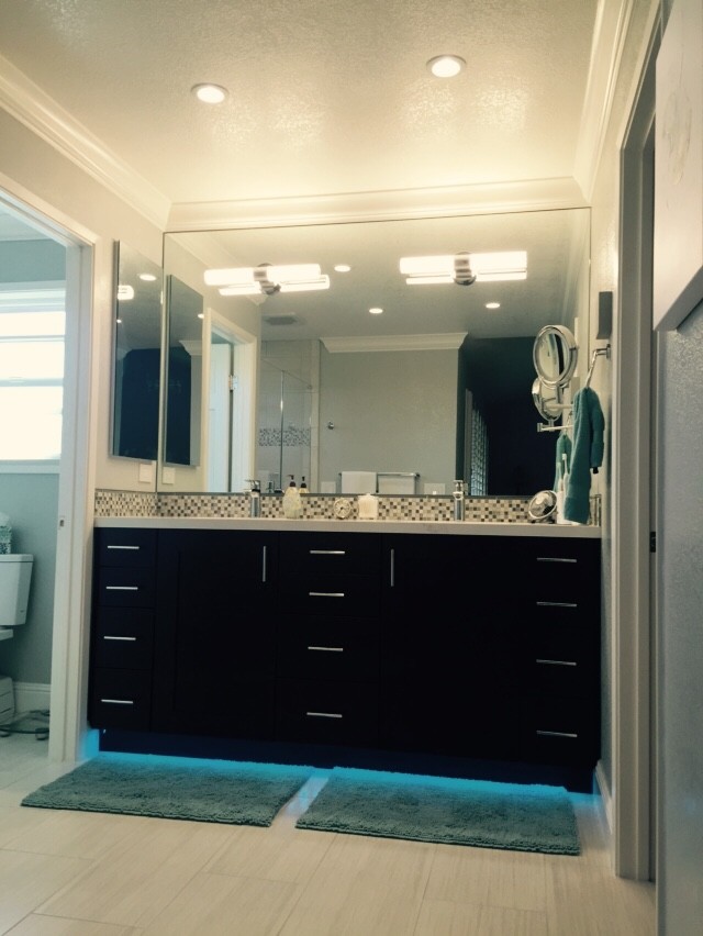 Foto de cuarto de baño principal contemporáneo con armarios con paneles lisos, puertas de armario de madera en tonos medios, ducha abierta y baldosas y/o azulejos grises