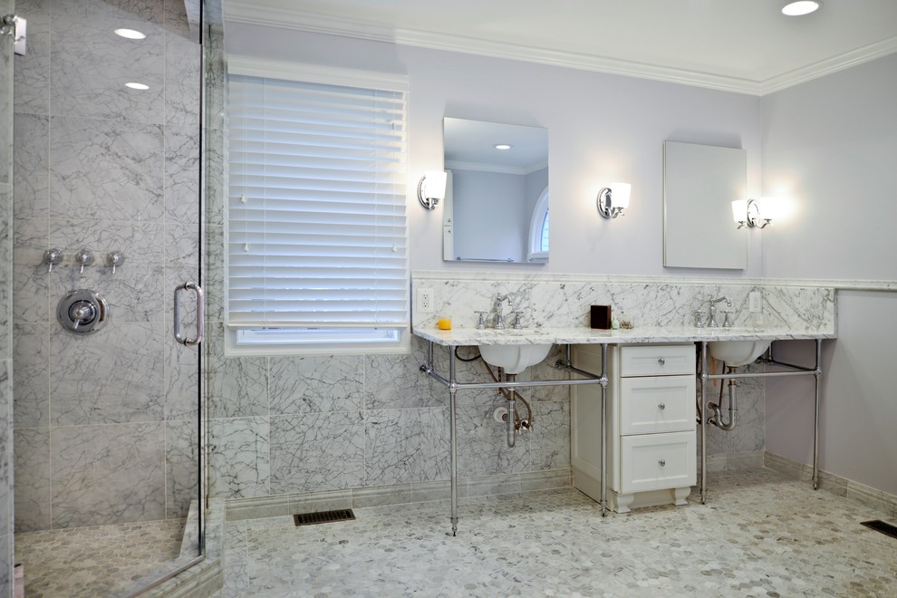 Cette image montre une salle de bain principale minimaliste avec des portes de placard blanches, un carrelage blanc, du carrelage en marbre, un mur blanc et un plan de toilette en marbre.