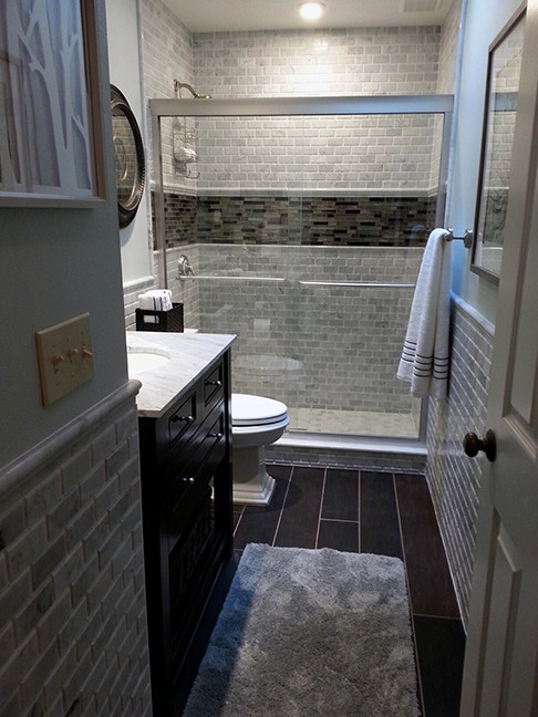 Bild på ett mellanstort vintage badrum med dusch, med möbel-liknande, skåp i mörkt trä, en dusch i en alkov, en toalettstol med separat cisternkåpa, grå kakel, porslinskakel, blå väggar, klinkergolv i porslin, ett undermonterad handfat och marmorbänkskiva