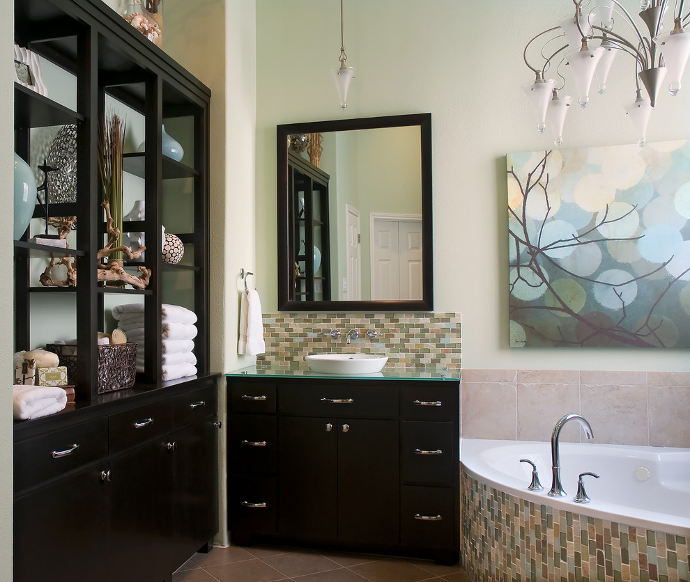 Источник вдохновения для домашнего уюта: большая главная ванная комната в стиле модернизм с плоскими фасадами, темными деревянными фасадами, угловой ванной, зелеными стенами, полом из керамической плитки, настольной раковиной, стеклянной столешницей, разноцветной плиткой и плиткой мозаикой