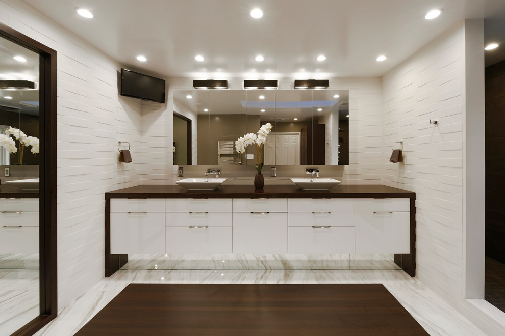 Aménagement d'une grande salle de bain contemporaine avec un placard à porte plane, des portes de placard blanches, un mur blanc et une vasque.