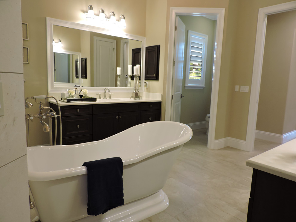 Idéer för stora medelhavsstil badrum, med ett fristående badkar, en öppen dusch, beige kakel, porslinskakel, beige väggar, klinkergolv i porslin, ett nedsänkt handfat, möbel-liknande, skåp i mörkt trä, en toalettstol med hel cisternkåpa och granitbänkskiva