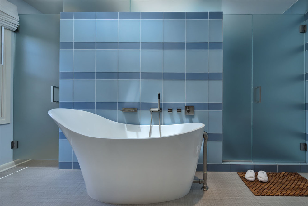 Esempio di una grande stanza da bagno padronale minimalista con ante lisce, ante in legno scuro, vasca freestanding, piastrelle blu, piastrelle di vetro e pavimento in gres porcellanato