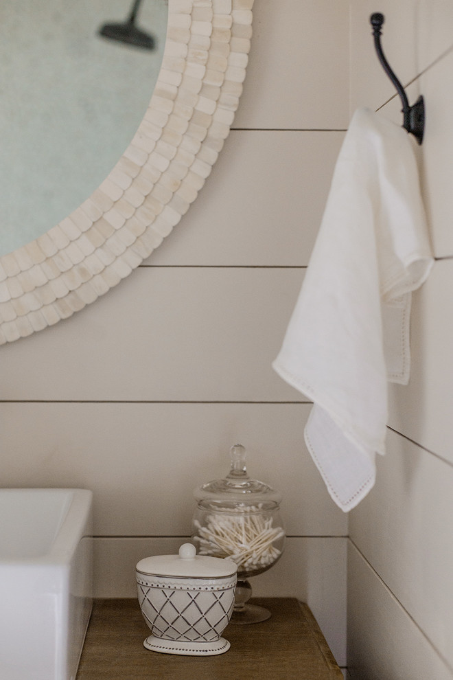 Cette image montre une salle de bain principale rustique en bois brun de taille moyenne avec une douche double, un carrelage blanc, une plaque de galets, un mur beige, un sol en galet, une vasque, un sol beige et aucune cabine.