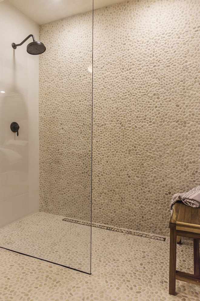 Lantlig inredning av ett mellanstort en-suite badrum, med skåp i mellenmörkt trä, en dubbeldusch, vit kakel, kakel i småsten, beige väggar, klinkergolv i småsten, ett fristående handfat, beiget golv och med dusch som är öppen