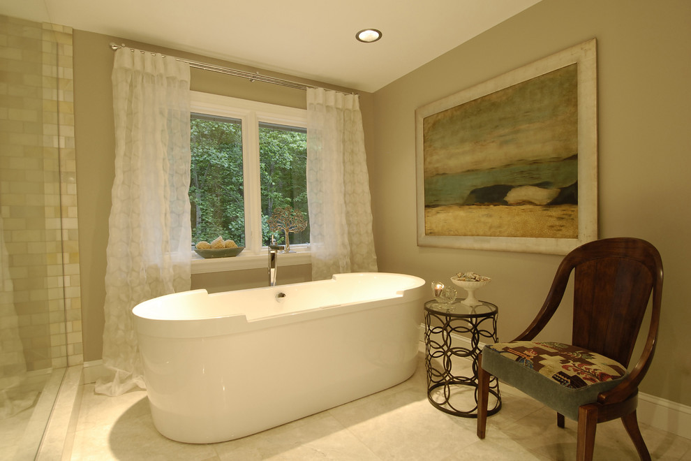 Foto på ett funkis badrum, med ett fristående badkar och beige kakel
