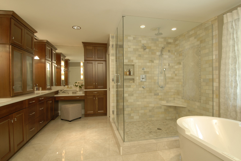 Photo of a classic bathroom in Raleigh with recessed-panel cabinets, medium wood cabinets, a freestanding bath, a corner shower, beige tiles and marble tiles.