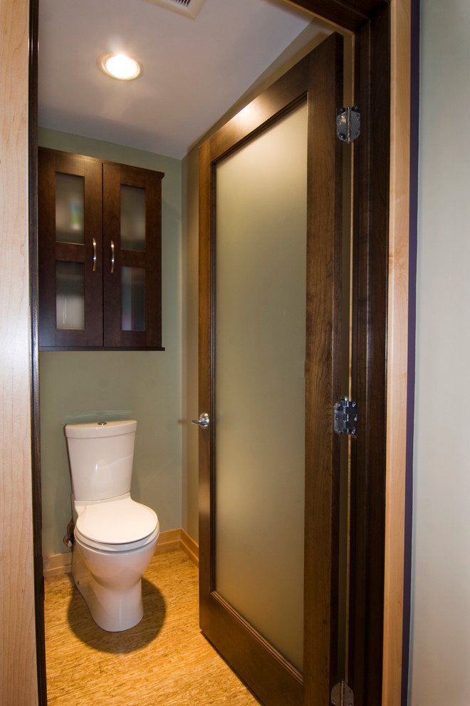 Photo of a large world-inspired ensuite bathroom in Grand Rapids with glass-front cabinets, dark wood cabinets, green walls and light hardwood flooring.