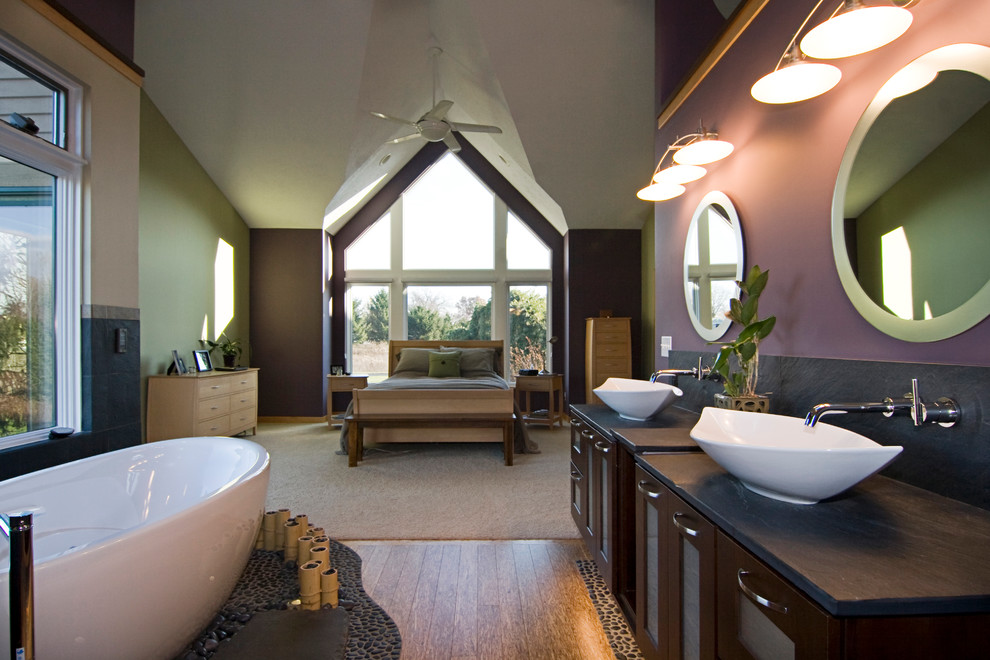 Freestanding bathtub - large zen master light wood floor freestanding bathtub idea in Grand Rapids with a vessel sink, glass-front cabinets, dark wood cabinets and purple walls