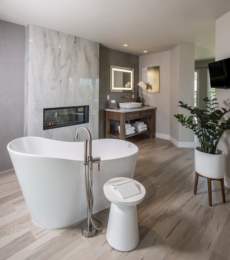 Example of a large trendy master white tile and marble tile vinyl floor and gray floor freestanding bathtub design in Phoenix with open cabinets, dark wood cabinets, gray walls, a vessel sink and white countertops