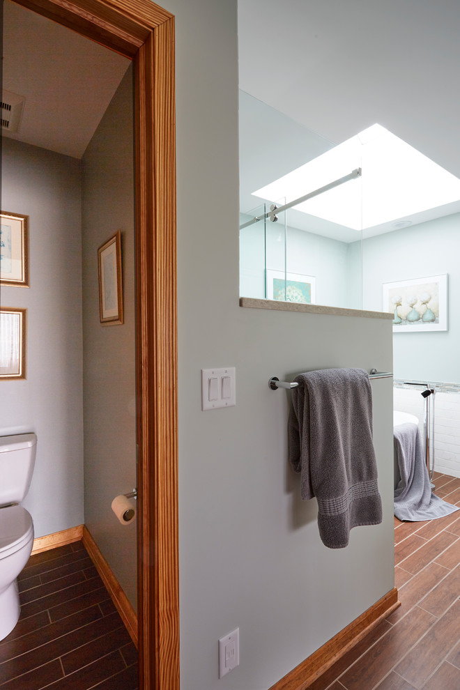 Источник вдохновения для домашнего уюта: большая главная ванная комната в стиле неоклассика (современная классика) с фасадами с утопленной филенкой, серыми фасадами, отдельно стоящей ванной, душем в нише, раздельным унитазом, белой плиткой, мраморной плиткой, синими стенами, паркетным полом среднего тона, врезной раковиной, столешницей из искусственного кварца, коричневым полом, душем с раздвижными дверями и серой столешницей