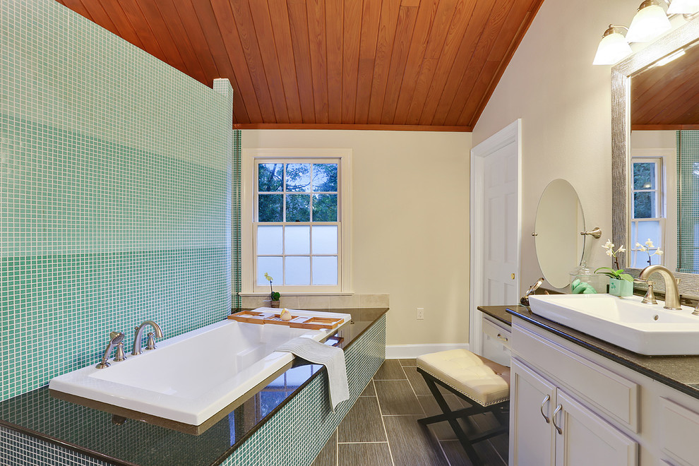 Klassisk inredning av ett stort en-suite badrum, med ett fristående handfat, luckor med upphöjd panel, vita skåp, granitbänkskiva, ett platsbyggt badkar, en öppen dusch, en toalettstol med hel cisternkåpa, blå kakel, glaskakel, vita väggar och klinkergolv i keramik