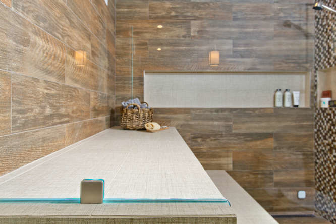 Aménagement d'un grand sauna classique en bois vieilli avec un placard avec porte à panneau encastré, WC à poser, un carrelage marron, des carreaux de porcelaine, un mur gris, un sol en carrelage de porcelaine, un lavabo encastré et un plan de toilette en quartz modifié.