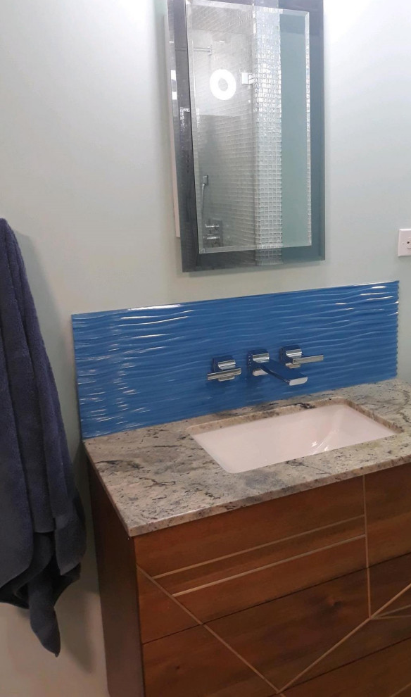 Inredning av ett modernt mellanstort grön grönt en-suite badrum, med möbel-liknande, skåp i mellenmörkt trä, ett fristående badkar, en kantlös dusch, en toalettstol med separat cisternkåpa, grön kakel, glaskakel, gröna väggar, klinkergolv i porslin, ett undermonterad handfat, granitbänkskiva, beiget golv och dusch med gångjärnsdörr