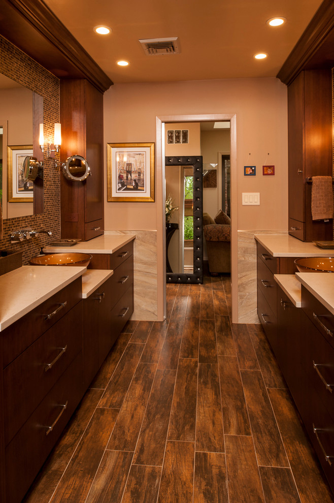 Пример оригинального дизайна: большая главная ванная комната в восточном стиле с настольной раковиной, плоскими фасадами, фасадами цвета дерева среднего тона, столешницей из искусственного кварца, керамогранитной плиткой, полом из керамогранита, отдельно стоящей ванной, угловым душем, коричневыми стенами, коричневым полом и душем с распашными дверями