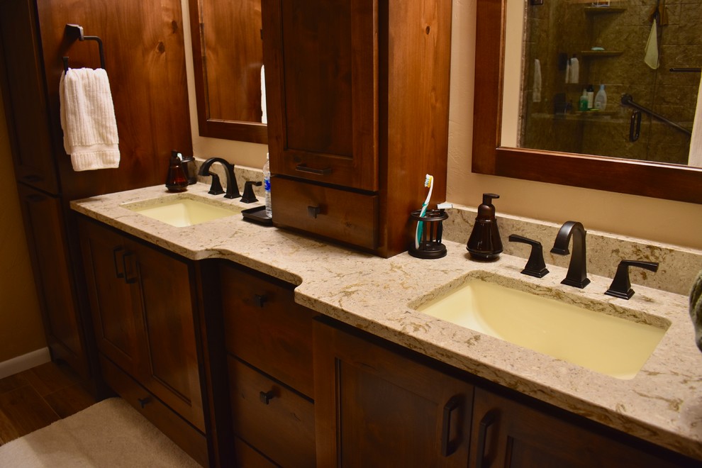This is an example of a traditional ensuite bathroom in Chicago with shaker cabinets, dark wood cabinets, a corner shower, a one-piece toilet, beige walls, ceramic flooring, a submerged sink, engineered stone worktops, brown floors and a hinged door.