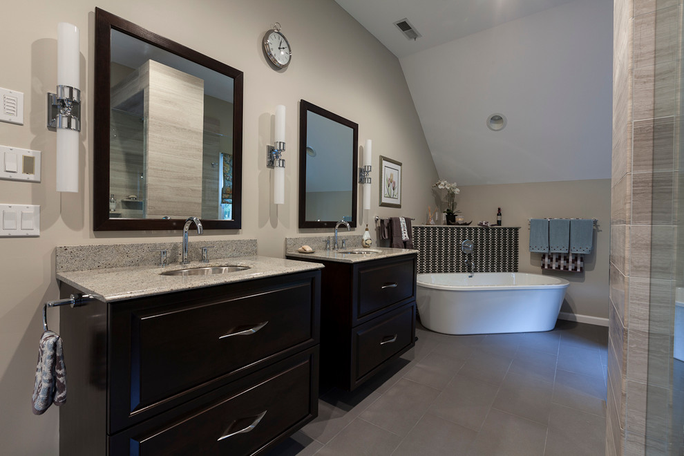 Large trendy master gray tile and stone tile porcelain tile bathroom photo in Bridgeport with an undermount sink, raised-panel cabinets, dark wood cabinets, granite countertops, a two-piece toilet and gray walls