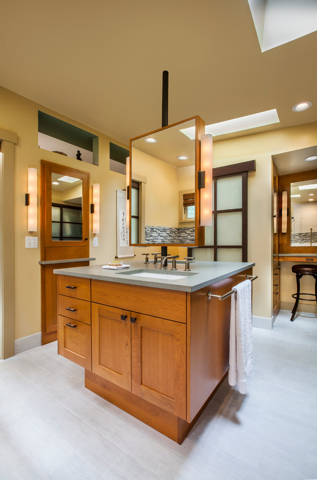 Imagen de cuarto de baño clásico con lavabo bajoencimera, paredes amarillas y encimeras grises