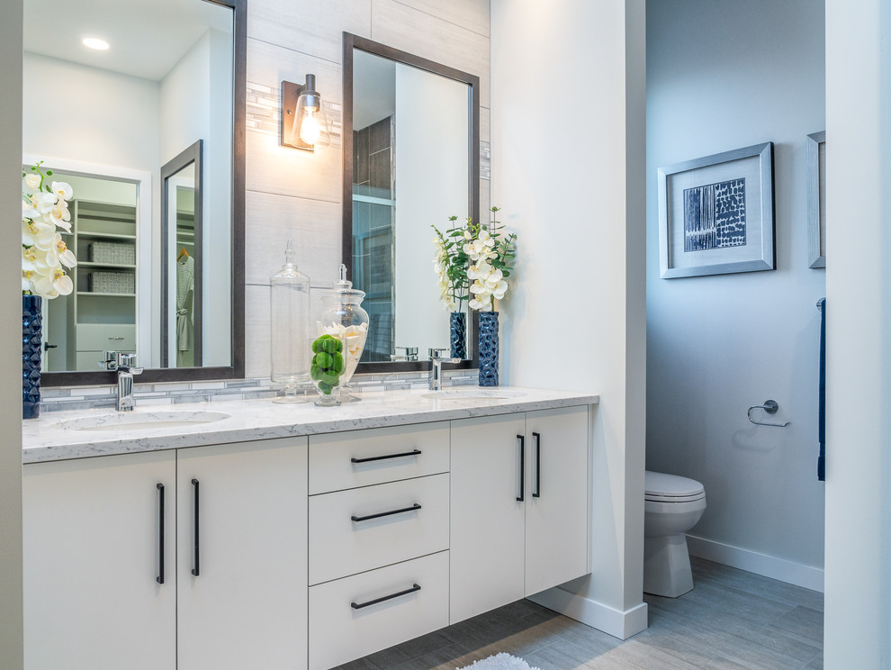 Ispirazione per una stanza da bagno minimal con ante lisce, ante bianche, pareti grigie, lavabo sottopiano, pavimento grigio e top bianco