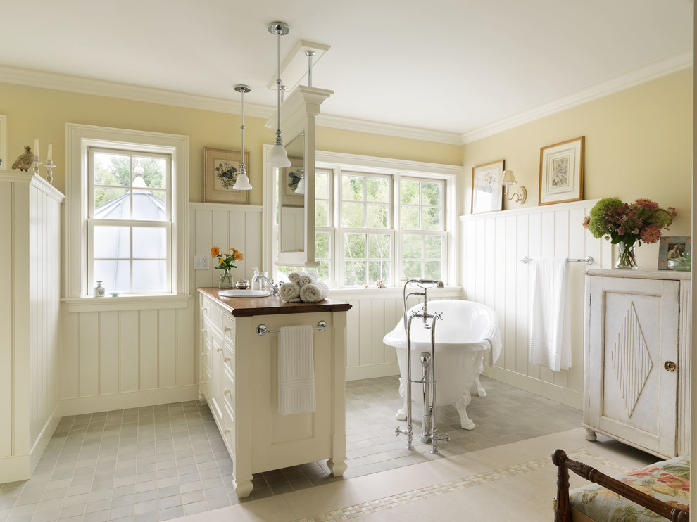 Inspiration for a timeless claw-foot bathtub remodel in Burlington with a drop-in sink and yellow walls