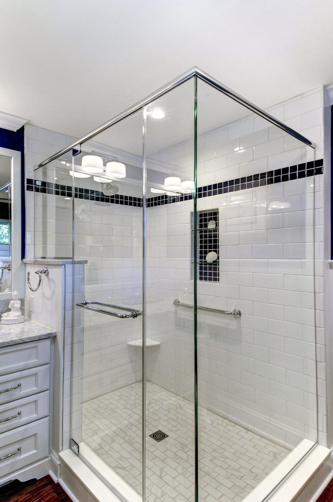 Идея дизайна: ванная комната в стиле неоклассика (современная классика) с белыми фасадами, белой плиткой, паркетным полом среднего тона, мраморной столешницей, коричневым полом, фасадами островного типа, угловым душем, плиткой кабанчик, синими стенами, врезной раковиной и душем с распашными дверями