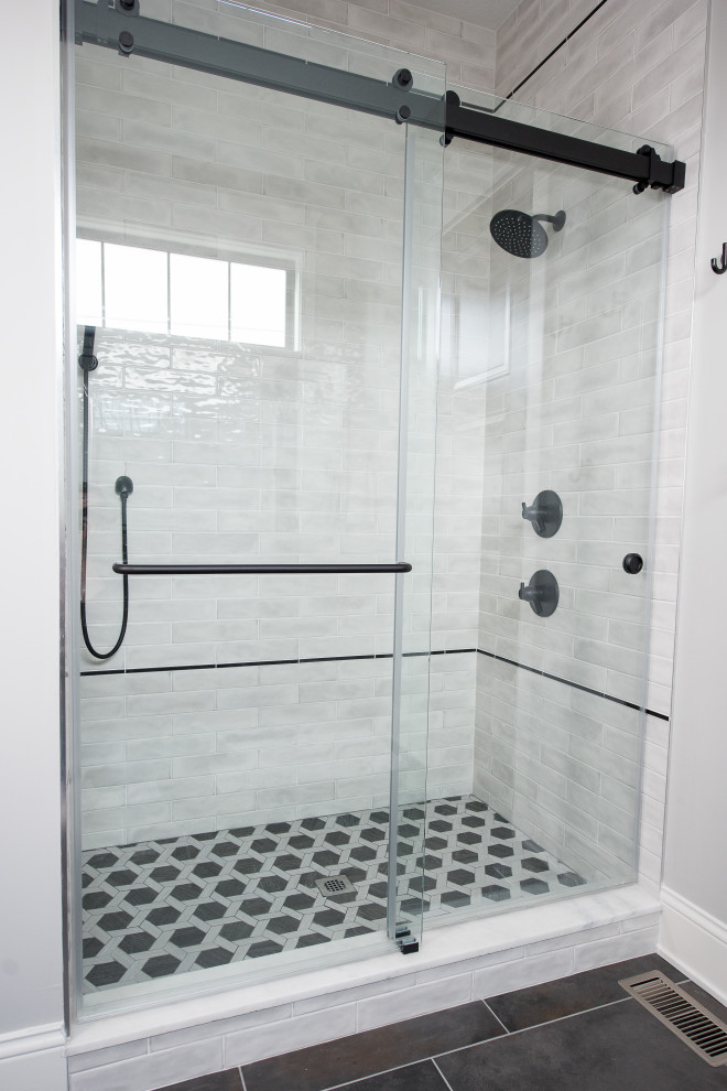 Exempel på ett mellanstort modernt en-suite badrum, med skåp i shakerstil, blå skåp, ett hörnbadkar, en dusch/badkar-kombination, en toalettstol med hel cisternkåpa, grå kakel, marmorkakel, vita väggar, mosaikgolv, ett undermonterad handfat och dusch med gångjärnsdörr