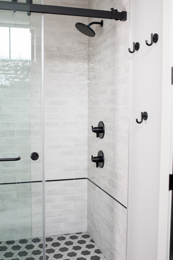 Cette image montre une salle de bain principale design de taille moyenne avec un placard à porte shaker, des portes de placard bleues, une baignoire d'angle, un combiné douche/baignoire, WC à poser, un carrelage gris, du carrelage en marbre, un mur blanc, un sol en carrelage de terre cuite, un lavabo encastré et une cabine de douche à porte battante.