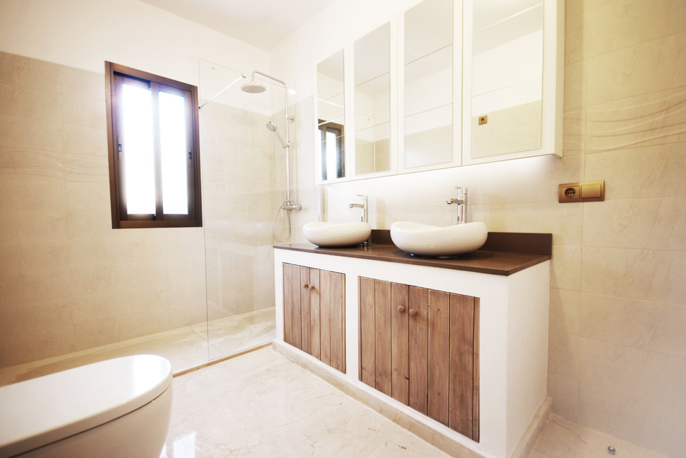 Inspiration for a medium sized contemporary shower room bathroom in Other with a vessel sink, medium wood cabinets, a built-in shower, a one-piece toilet, ceramic tiles, beige walls, travertine flooring, solid surface worktops, brown worktops and flat-panel cabinets.