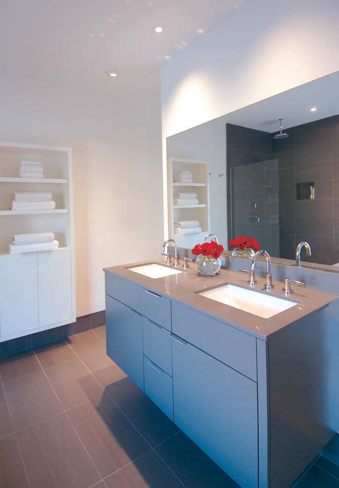 Modelo de cuarto de baño moderno con armarios con paneles lisos, puertas de armario grises y encimeras azules