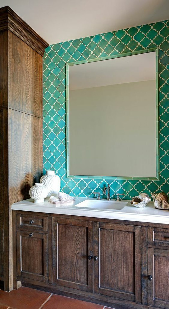 Cette image montre une salle de bain méditerranéenne en bois foncé avec un plan de toilette blanc.