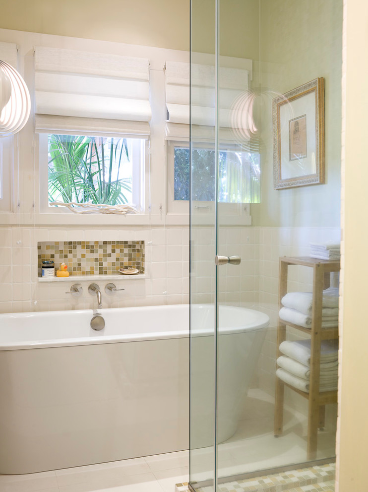 Пример оригинального дизайна: главная ванная комната среднего размера в стиле модернизм с врезной раковиной, плоскими фасадами, светлыми деревянными фасадами, мраморной столешницей, отдельно стоящей ванной, угловым душем, разноцветной плиткой, стеклянной плиткой, бежевыми стенами и полом из известняка