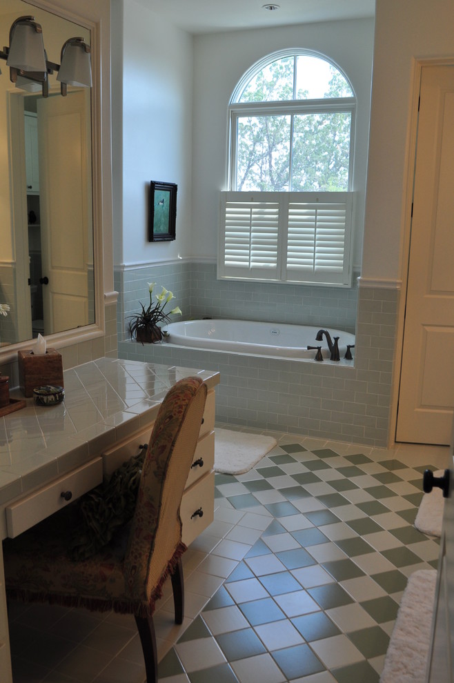 オースティンにある高級な広いサンタフェスタイルのおしゃれなマスターバスルーム (白いキャビネット、アルコーブ型浴槽、アルコーブ型シャワー、セラミックタイル、オーバーカウンターシンク、タイルの洗面台、フラットパネル扉のキャビネット、青いタイル、緑のタイル、白いタイル、ベージュの壁、セラミックタイルの床) の写真