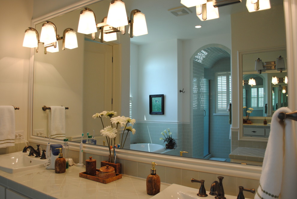 Exempel på ett stort amerikanskt en-suite badrum, med vita skåp, ett badkar i en alkov, en dusch i en alkov, beige kakel, keramikplattor, ett nedsänkt handfat, kaklad bänkskiva, släta luckor, beige väggar och klinkergolv i keramik