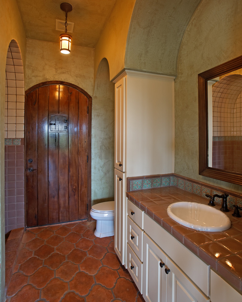 Idee per una stanza da bagno mediterranea con lavabo da incasso e pavimento in terracotta