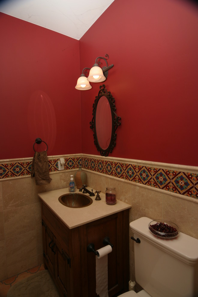 Источник вдохновения для домашнего уюта: туалет среднего размера в средиземноморском стиле с фасадами в стиле шейкер, темными деревянными фасадами, раздельным унитазом, красными стенами, полом из керамической плитки, накладной раковиной и мраморной столешницей