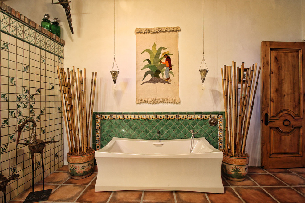 На фото: ванная комната в стиле фьюжн с отдельно стоящей ванной, зеленой плиткой, бежевыми стенами и полом из терракотовой плитки с