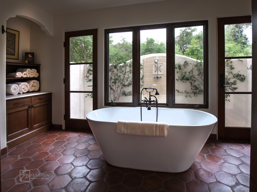 Ispirazione per una stanza da bagno padronale mediterranea di medie dimensioni con ante con riquadro incassato, ante in legno bruno, top in pietra calcarea e piastrelle beige