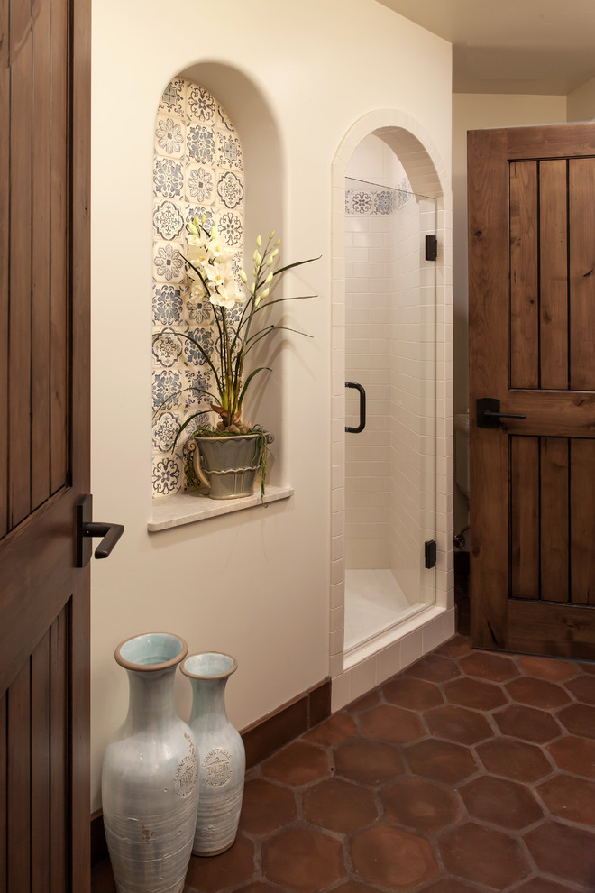 Photo of a large mediterranean shower room bathroom in Santa Barbara with a submerged sink, recessed-panel cabinets, dark wood cabinets, an alcove shower, a two-piece toilet, beige tiles, terracotta tiles, white walls and terracotta flooring.