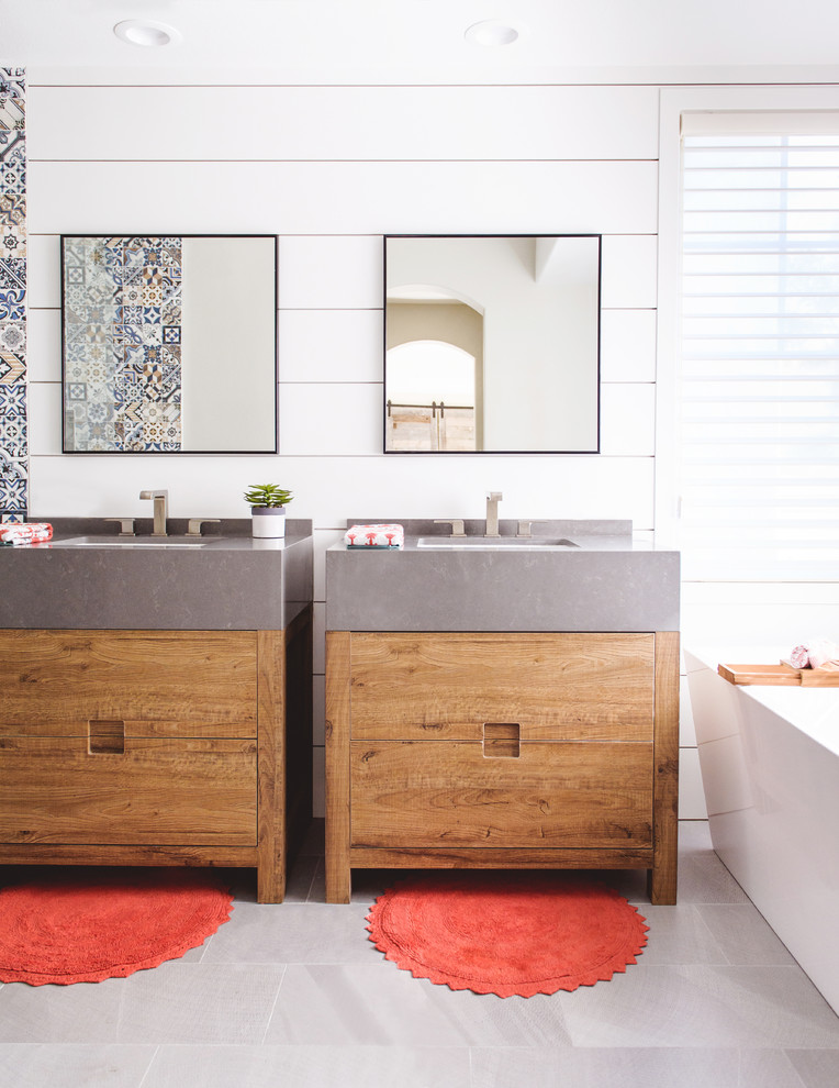 Photo of a medium sized modern ensuite bathroom in San Diego with flat-panel cabinets, medium wood cabinets, a freestanding bath, grey floors, blue tiles, white tiles, cement tiles, white walls and a submerged sink.