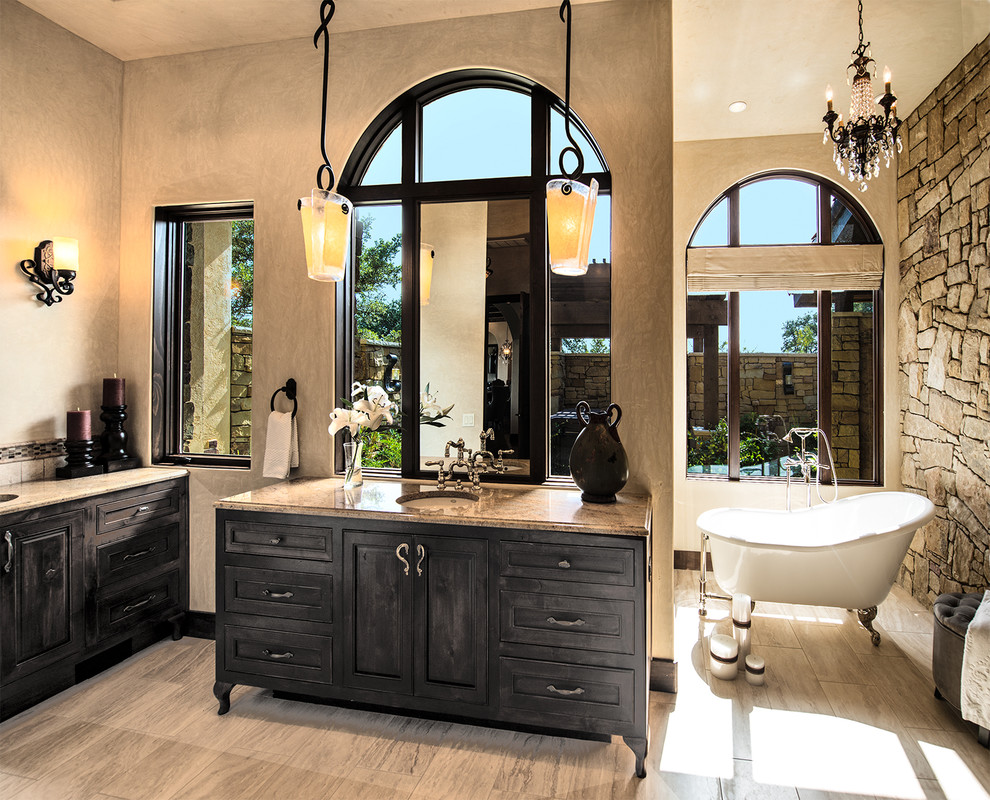 Design ideas for a mediterranean ensuite bathroom in Austin with a submerged sink, freestanding cabinets, dark wood cabinets, granite worktops, a claw-foot bath, black tiles, beige walls and ceramic flooring.